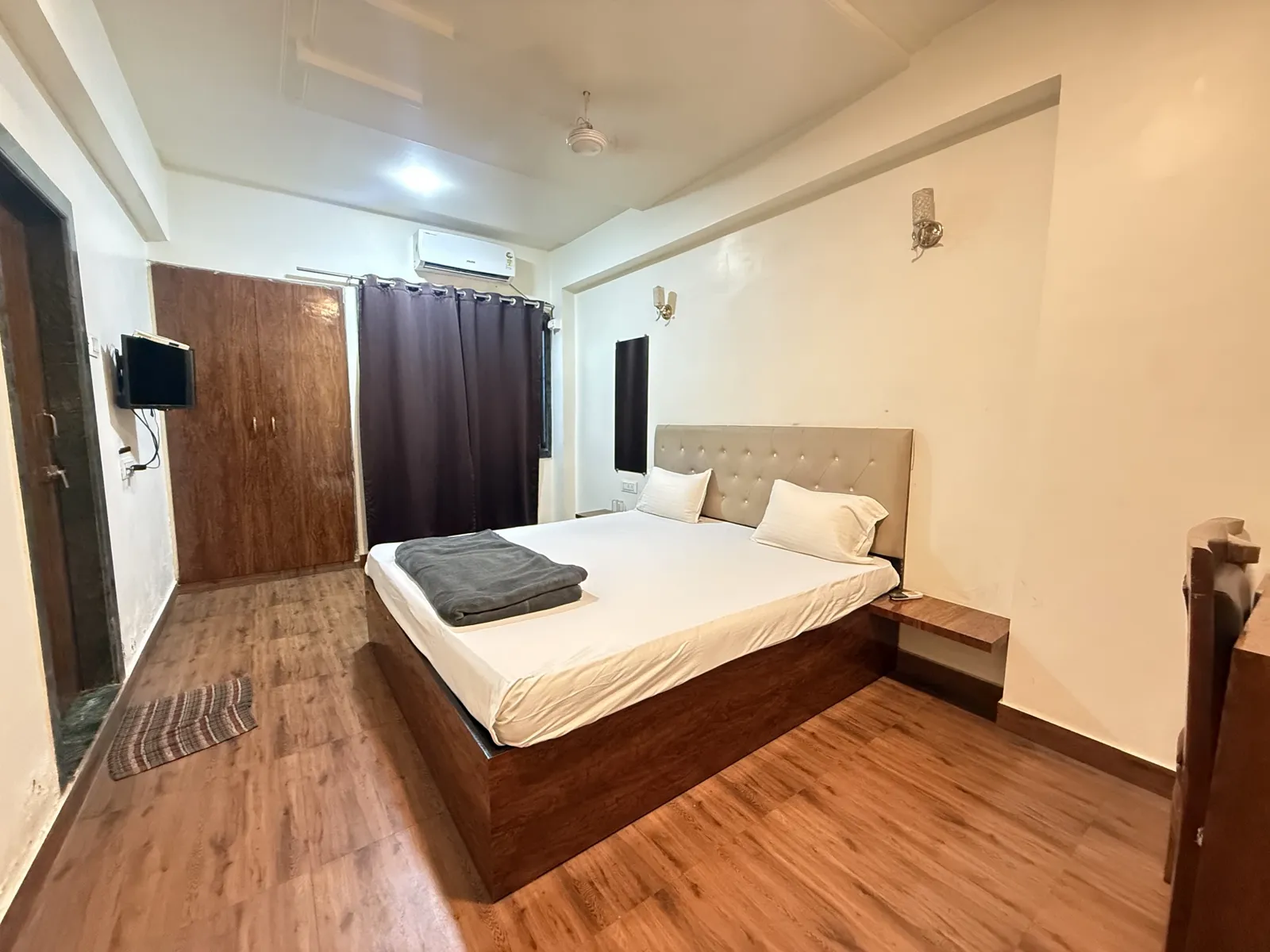Semi Deluxe room at Hotel Evershine with double bed, cushioned headboard, wall TV, wardrobe and wooden flooring